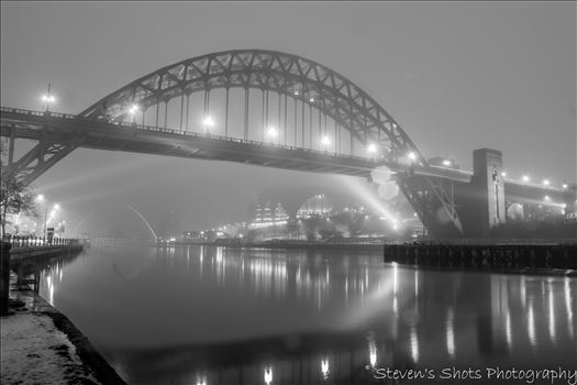 A foggy night on the River Tyne looking at the Tyne Bridge and the Sage is barely visible in the background.