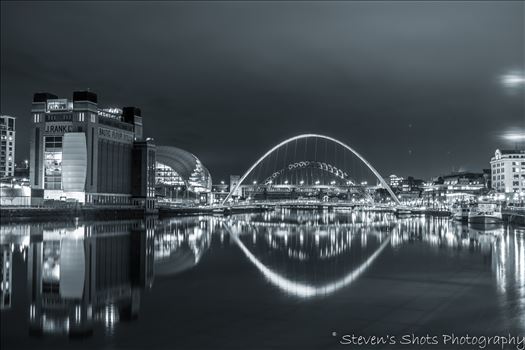 A black and white picture of the Millennium Bridge and Tyne Bridge on Newcastle quayside, the Baltic is visible also.