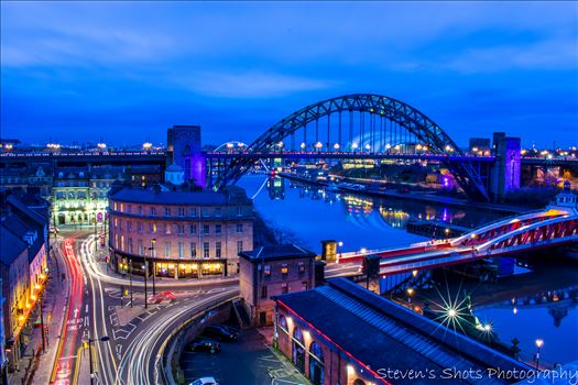 A long exposure shot from the high level bridge in Newcastle, showing the Tyne Bridge and Swing Bridge with traffic down on the quayside.